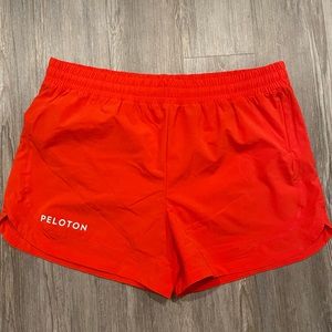 Peloton orange running shorts with inner lining